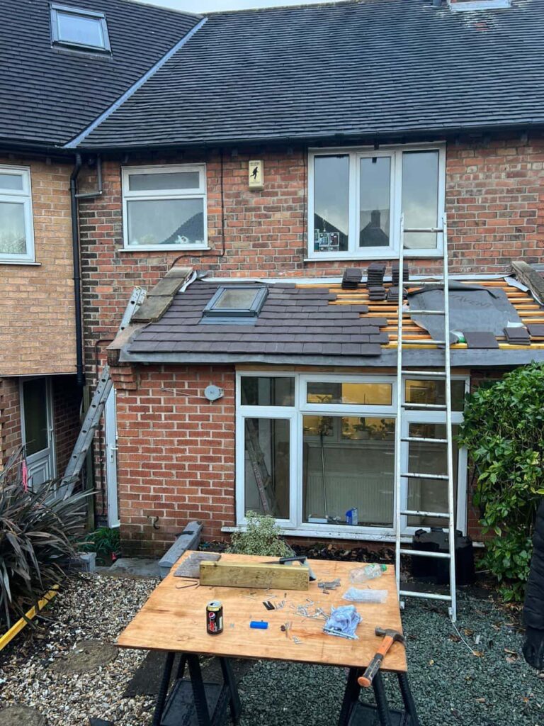 This is a photo of a roof extension that is having new roof tiles installed. This is a photo taken from the roof ridge looking down a tiled pitched roof on to a flat roof. Works carried out by Chislehurst Roofing Repairs